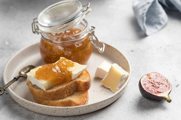 Desayuno tostadas picatostes con queso camembert y mermelada de higos servido en plato de cerámica cocina francesa