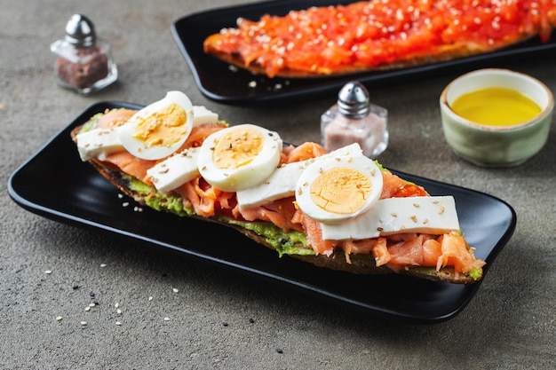 Desayuno tradicional español Tostada con diferentes coberturas sobre un fondo oscuro