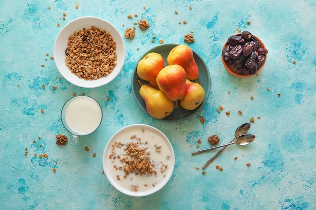 Desayuno tradicional europeo. Leche y granola. Muesli, dátiles y peras frescas.