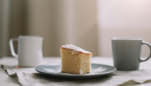 Desayuno con un trozo de tarta casera en un plato y una taza de café