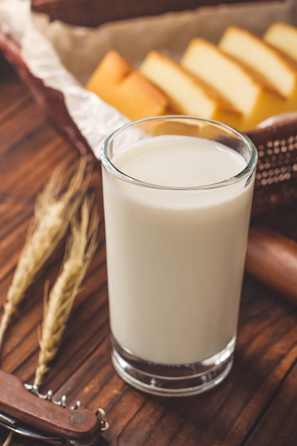 Foto desayuno con un vaso de leche y pastel.