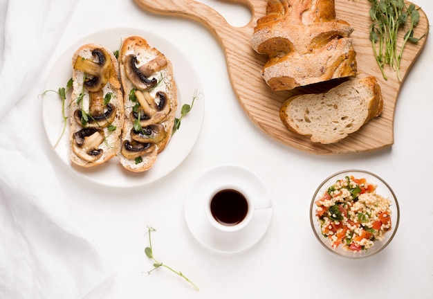 Desayuno vegetariano sin productos cárnicos. sobre una mesa blanca de café, una ensalada de tabule de bulgur, bocadillos de champiñones.