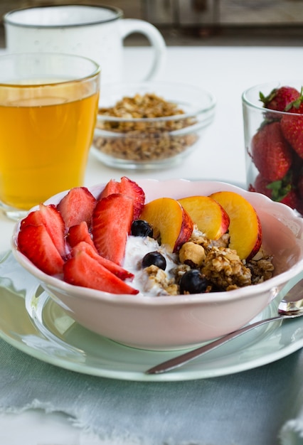 Foto desayuno vegetariano saludable. un bol de granola, bayas y fruta.