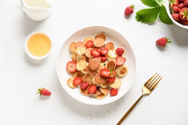 Desayuno de verano con mini panqueques en superficie blanca