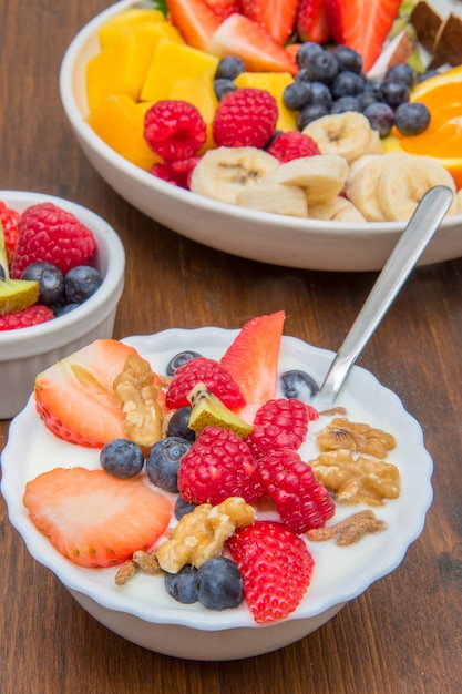 Foto desayuno con yogur, fruta y cereales.