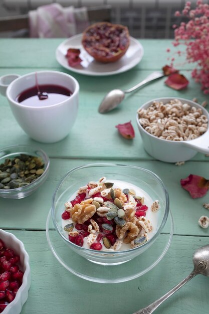 Desayuno con yogur, frutos secos, cereales y semillas de granada. Desayuno saludable