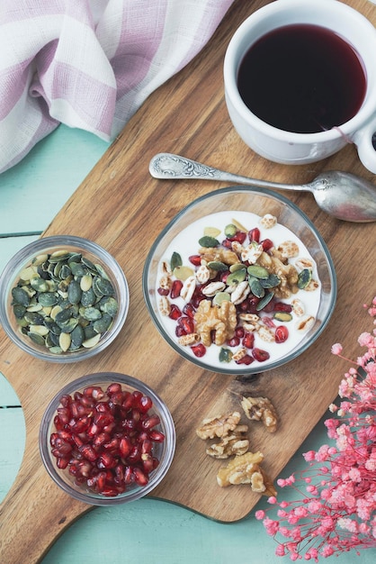 Desayuno con yogur, frutos secos, cereales y semillas de granada. Desayuno saludable