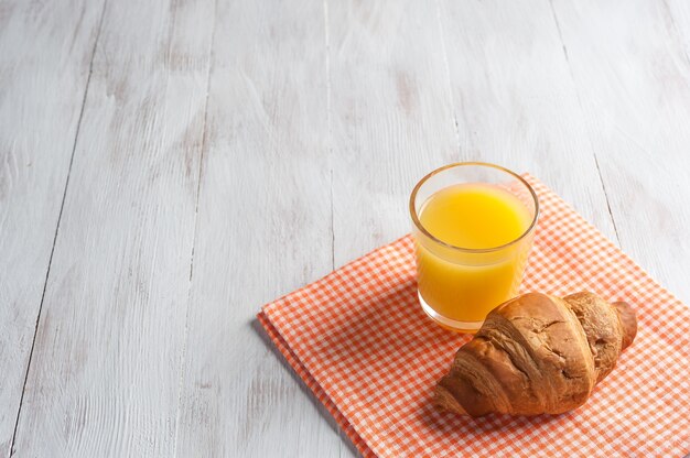 Desayuno con zumo de naranja y croissant