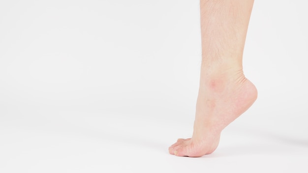 Descalço e as pernas do homem asiático são isolados no fundo branco.