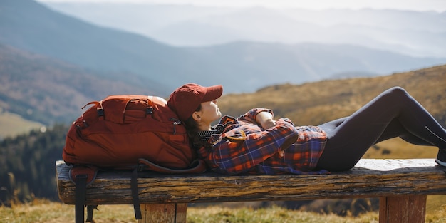 Descansando mujer excursionista tendido disfrutando del sol durante el viaje de senderismo trek hermosa hembra joven