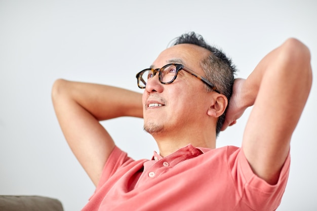 descanse, relaxe e conceito de pessoas - homem de óculos relaxando ou sonhando em casa