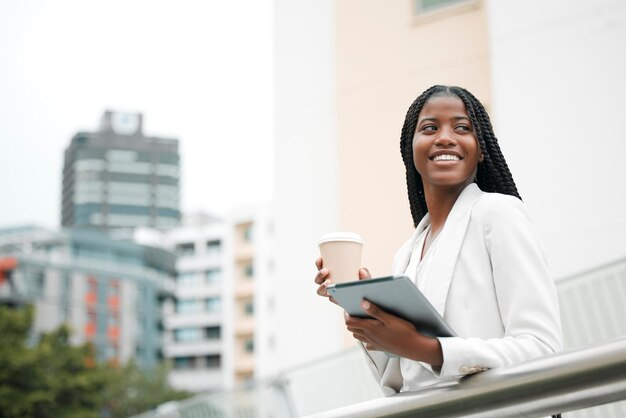 Descanso de café de mujer negra y empleada corporativa con tableta fuera de la oficina trabajando en una ciudad y comercializadora profesional Tecnología digital Profesional afroamericana y mujer de negocios al aire libre