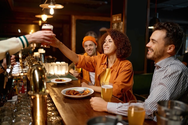 Descanso feliz de la compañía de amigos en el bar deportivo juntos