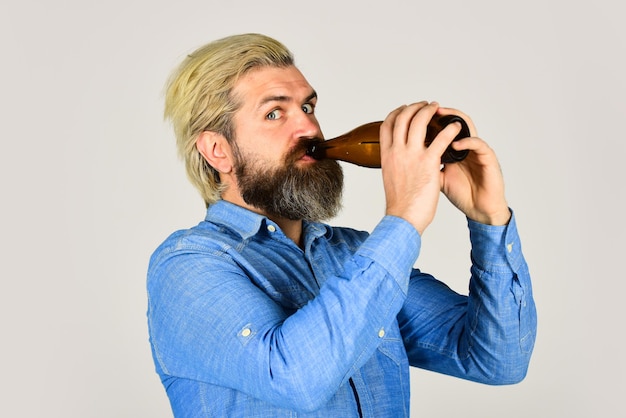 Descanso inconformista en pub. Amante de los deportes anímate. hombre maduro sosteniendo una botella de cerveza. cerveza embotellada artesanal masculina inconformista borracho. hombre feliz sostenga la botella de vidrio llena en la mano. macho sosteniendo una botella de cerveza.