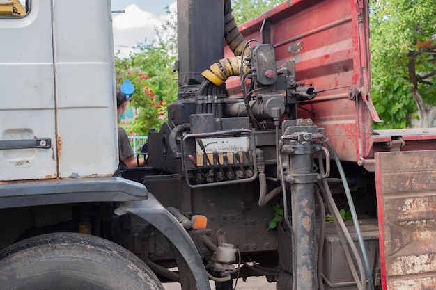 Descarga de losas de pavimento de un camión Hombres descargan losas de pavimento usando un manipulador Trabajadores descargan materiales de construcción de una máquina grande