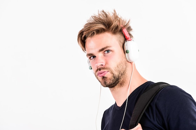 Descargar aplicación de música Gusto de música juvenil Hombre peinado despeinado use auriculares de plástico gadget Disfrute de la música donde quiera que vaya Estudiante chico guapo escuchando música Concepto de melodía rítmica