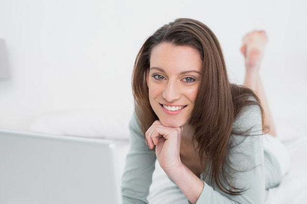 Descontraída, casual, sorrindo, mulher, usando, laptop, cama