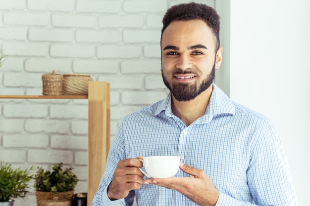 Descontraído empresário negro no escritório, beber café