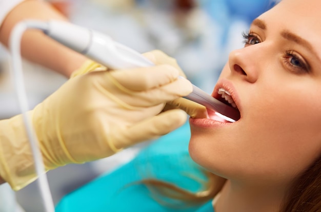 Descripción general de la prevención de la caries dental Mujer en la silla del dentista durante un procedimiento dental.