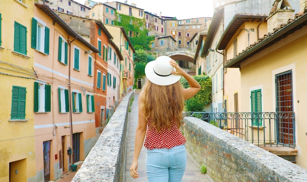 Descubriendo Italia. Vista posterior de la joven y atractiva mujer caminando en la vieja ciudad italiana.