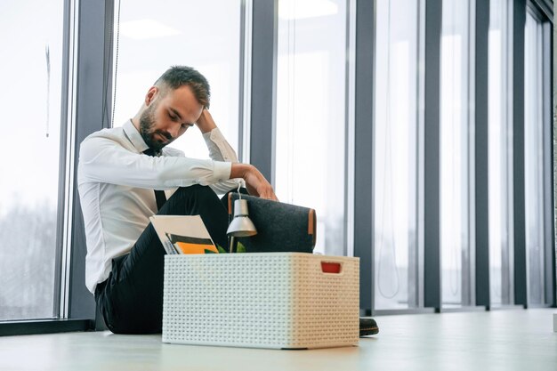 El desempleado está con sus pertenencias personales después de ser despedido.