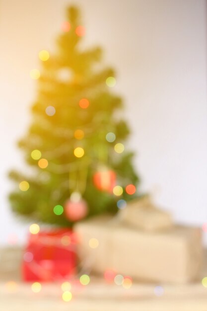 Desenfoque de fondo, celebración de luz en el árbol de navidad con caja de regalo en la sala de estar