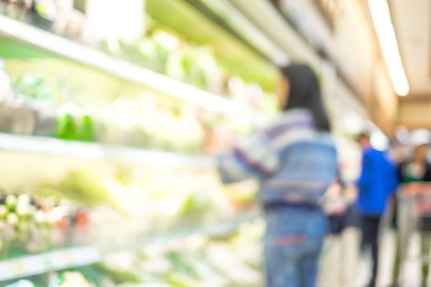 Desenfoque de fondo de cliente mujer seleccione producto fresco en estante en supermercado