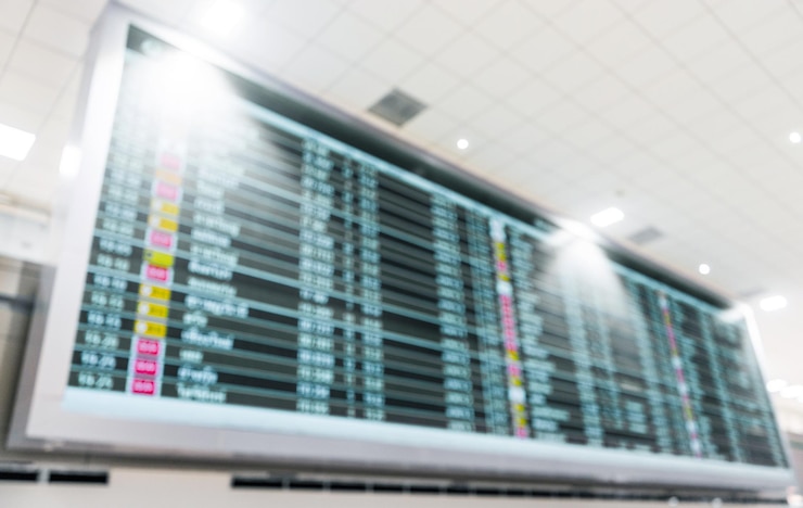 Foto desenfoque de horario de información de vuelo en la pantalla de a bordo en el fondo del aeropuerto
