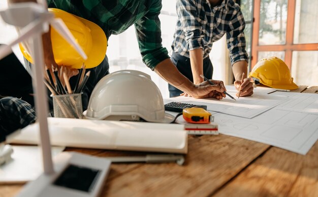 Desenho de reunião de trabalho em equipe de engenheiro trabalhando em reunião de projeto para projeto trabalhando com parceiro na construção de modelo no escritório da empresa Equipe profissional da indústria asiática xA