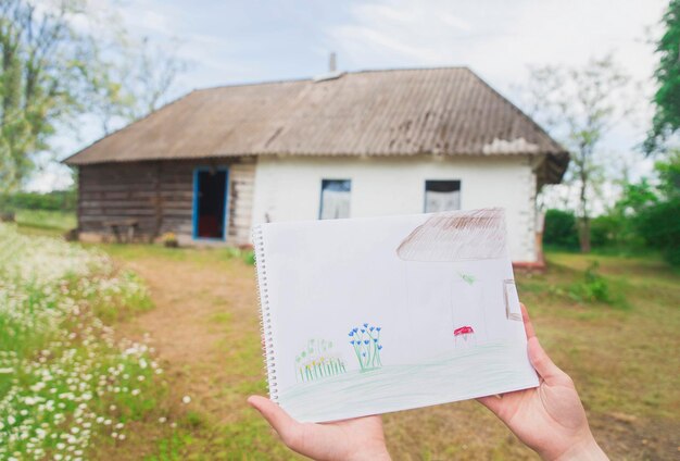 Desenho infantil de uma velha cabana de madeira com jardim