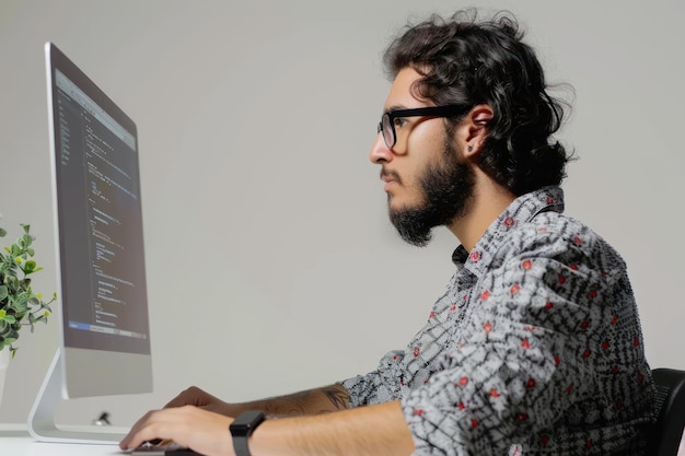 Foto desenvolvedor focado codificador usa óculos trabalhando em computador isolado em fundo branco sólido