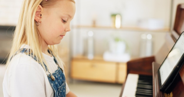 Desenvolvimento de menina e piano para aprender prática e teclas para instrumento sendo foco concentrado e educar Tablet de música e educação infantil para jogar lição e treinar arte em casa