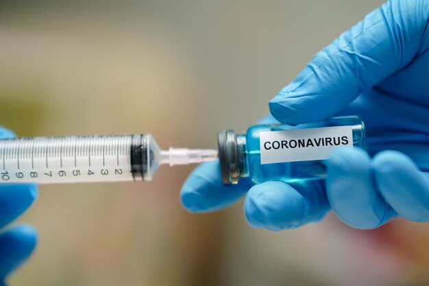 Desenvolvimento inovador da vacina contra o coronavírus médico com seringa para médico.