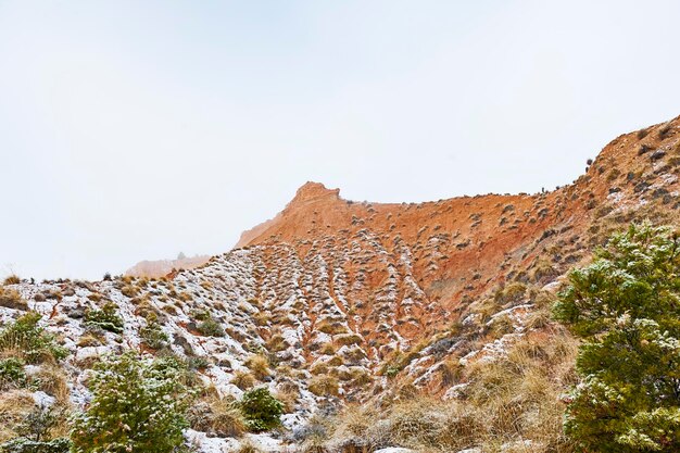Deserto com montanhas marrons parcialmente cobertas de neve.