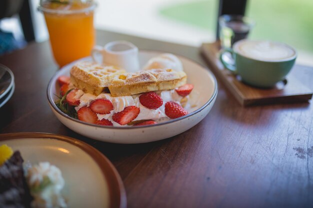 Deserto de panqueca de waffle com sorvete de baunilha, morango fresco e calda de mel