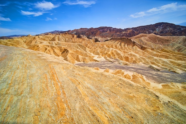 Deserto icônico Zabriskie Point no Vale da Morte durante o dia com ondas coloridas