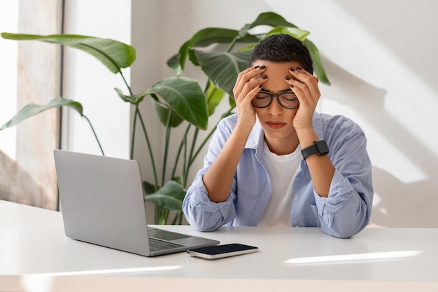 Desesperada infeliz joven latina con gafas sufre de migraña