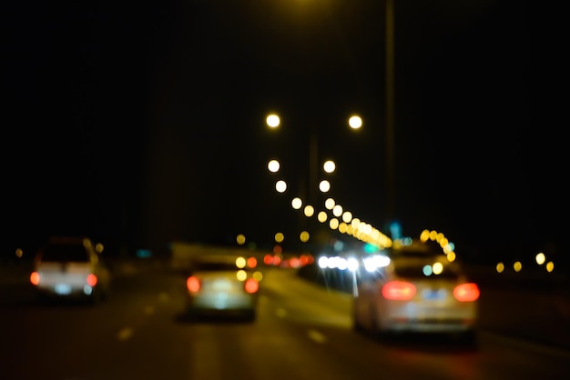 Desfocado de carro leve bokeh na estrada à noite