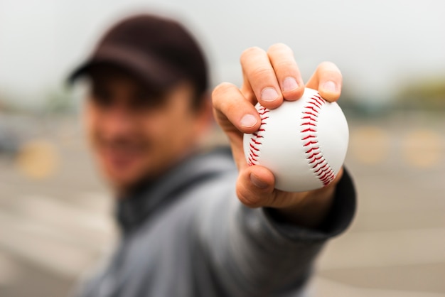 Desfocado homem segurando beisebol na mão
