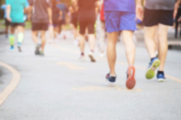 Desfocar foto grupo de pessoas multidão. pés de corredor de atleta fazendo exercício em pista de corrida na estrada