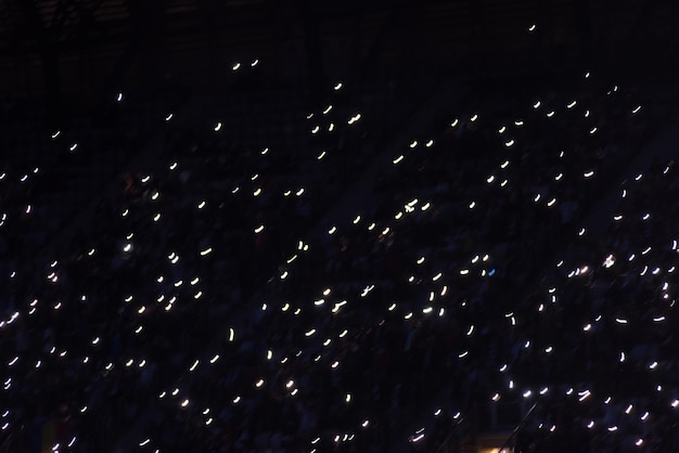 Desfoque de movimento de telefones inteligentes brilhantes em uma tribuna escura