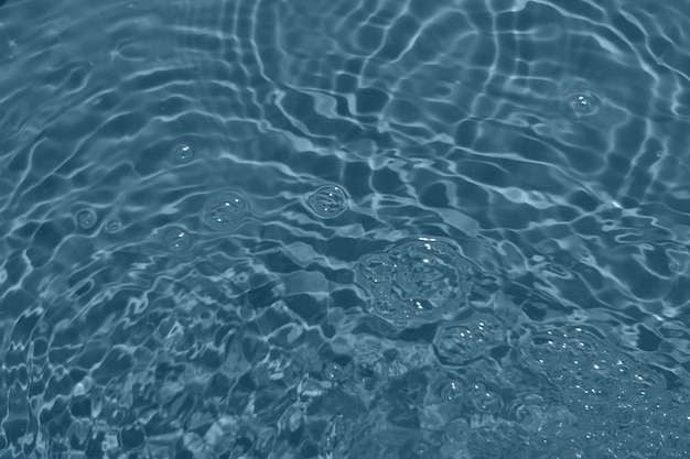 Desfoque turva, transparente, de cor azul, textura de superfície de água calma e clara com salpicos e bolhas Fundo de natureza abstrata na moda Onda de água à luz do sol com espaço de cópia Textura de aquarela azul
