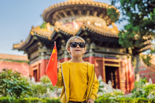 Desfrutando de férias na China Menino com bandeira nacional chinesa na Cidade Proibida Viajar para a China com conceito de crianças Trânsito sem visto 72 horas 144 horas na China