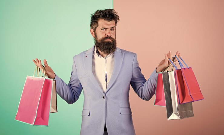 Foto desfrutar de compras black friday hipster compras com desconto homem barbudo hipster empresário terno formal carregar sacos de papel compras pronto para o feriado comprar presentes para todos comprar presentes com antecedência