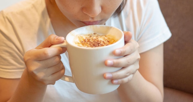 Desfrute de uma xícara de café cappucinno quente na luz quente