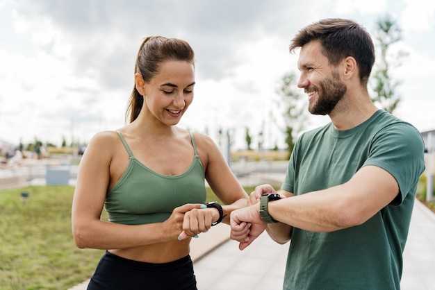 Desfrute do relógio de fitness e do aplicativo Exercícios de equipe de casal jovem Treinamento de atletas masculinos e femininos