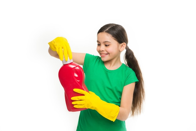 Desfrute lavando sua roupa. limpador bonito usando luvas de borracha amarelas. criança pequena segurando o sabão em pó nas mãos. usando produtos de limpeza doméstica. criança pronta para a lavagem doméstica.
