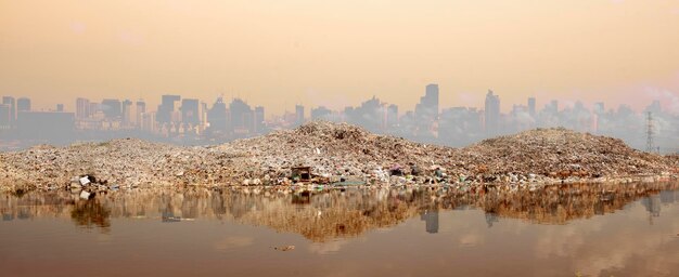 Deshechos tóxicos de las industrias de manos humanas que crean contaminación y ciudades que se ven afectadas