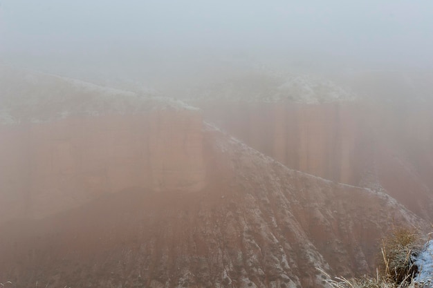 Desierto con montañas marrones parcialmente cubiertas de nieve.