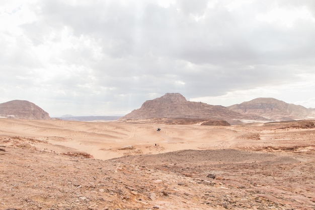 Desierto, montañas rojas, rocas y cielo nublado. Egipto, cañón de color.